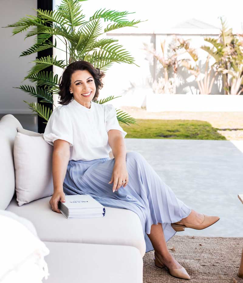 The Perth Fashion Stylist Rosalinda Panton sitting on couch on patio reading books